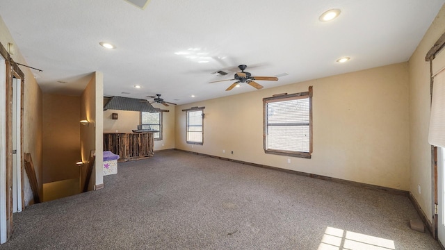 unfurnished living room with ceiling fan and carpet floors