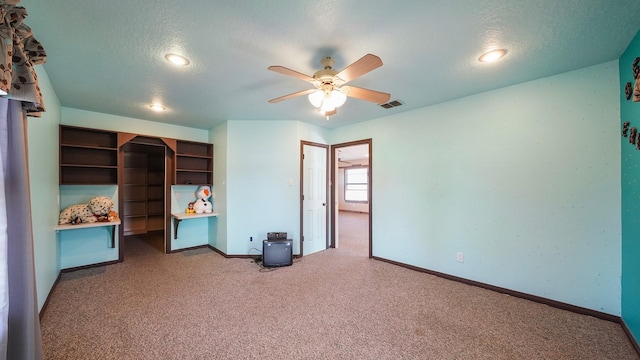 unfurnished bedroom featuring ceiling fan, carpet, and a textured ceiling