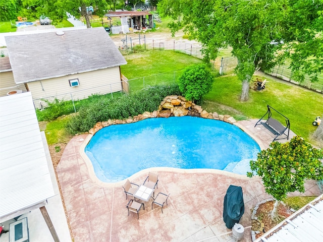 view of pool with a lawn and a patio