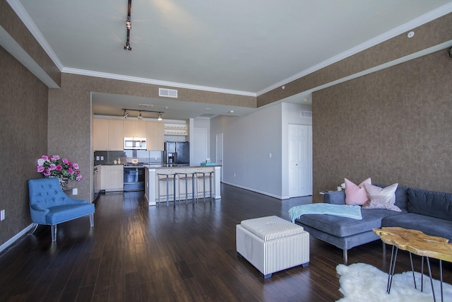 living room featuring dark hardwood / wood-style flooring, rail lighting, and ornamental molding