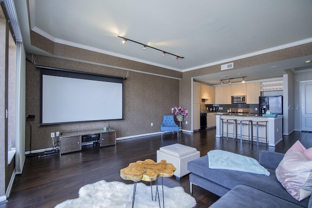 cinema featuring rail lighting, dark hardwood / wood-style floors, and crown molding