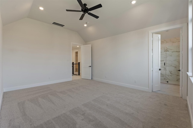 unfurnished bedroom with ensuite bathroom, ceiling fan, light colored carpet, and vaulted ceiling