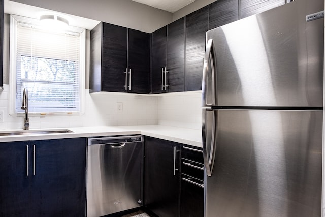 kitchen featuring decorative backsplash, sink, and appliances with stainless steel finishes