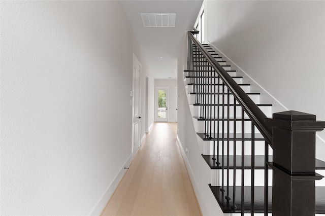 hallway with light hardwood / wood-style floors