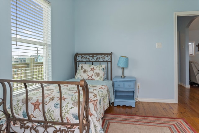 bedroom with hardwood / wood-style flooring and multiple windows