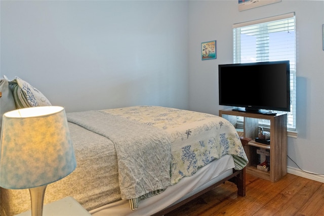 bedroom with multiple windows and hardwood / wood-style flooring