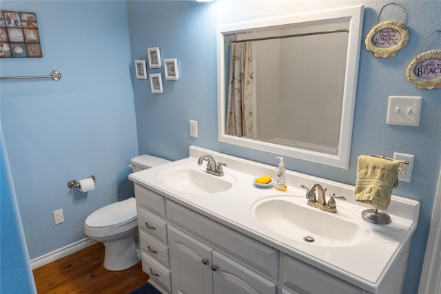 bathroom with a shower with shower curtain, hardwood / wood-style floors, vanity, and toilet