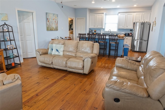 living room with light hardwood / wood-style floors and sink