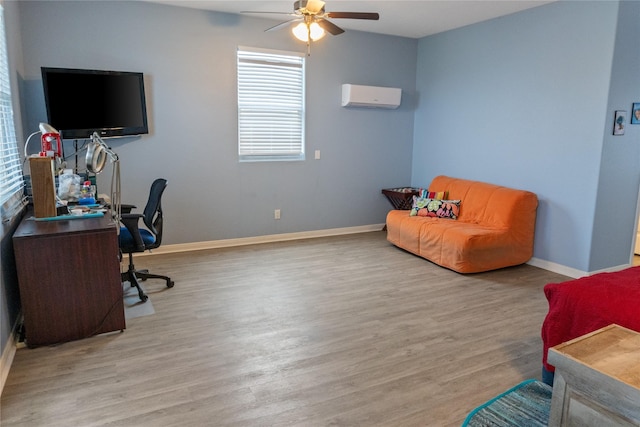 office space with light hardwood / wood-style floors, a wall mounted AC, and ceiling fan