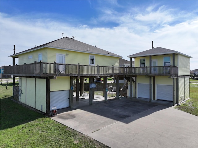 rear view of house with a yard, a deck, and a carport