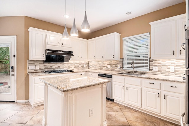 kitchen featuring hanging light fixtures, sink, decorative backsplash, appliances with stainless steel finishes, and a kitchen island