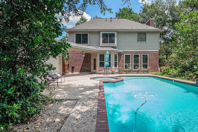 view of pool with a patio area and an in ground hot tub