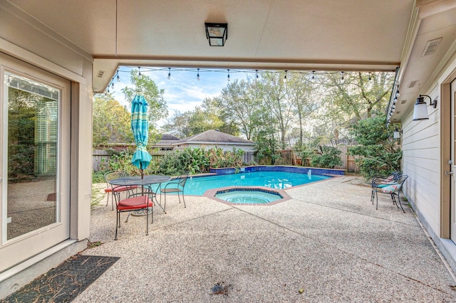 view of pool with a patio area and an in ground hot tub