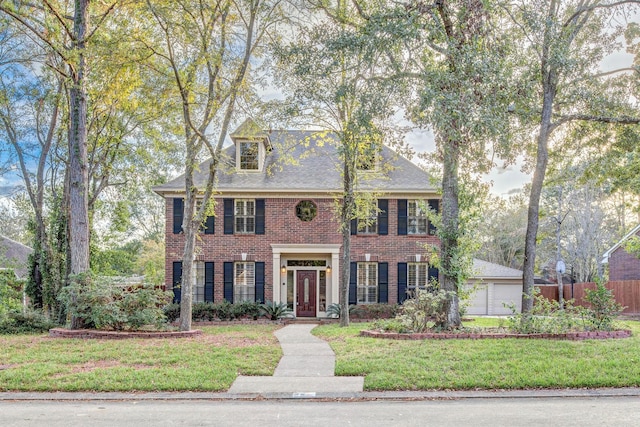 colonial inspired home featuring a front lawn