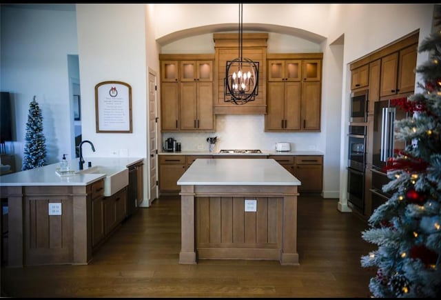 kitchen featuring sink, hanging light fixtures, an island with sink, appliances with stainless steel finishes, and a chandelier