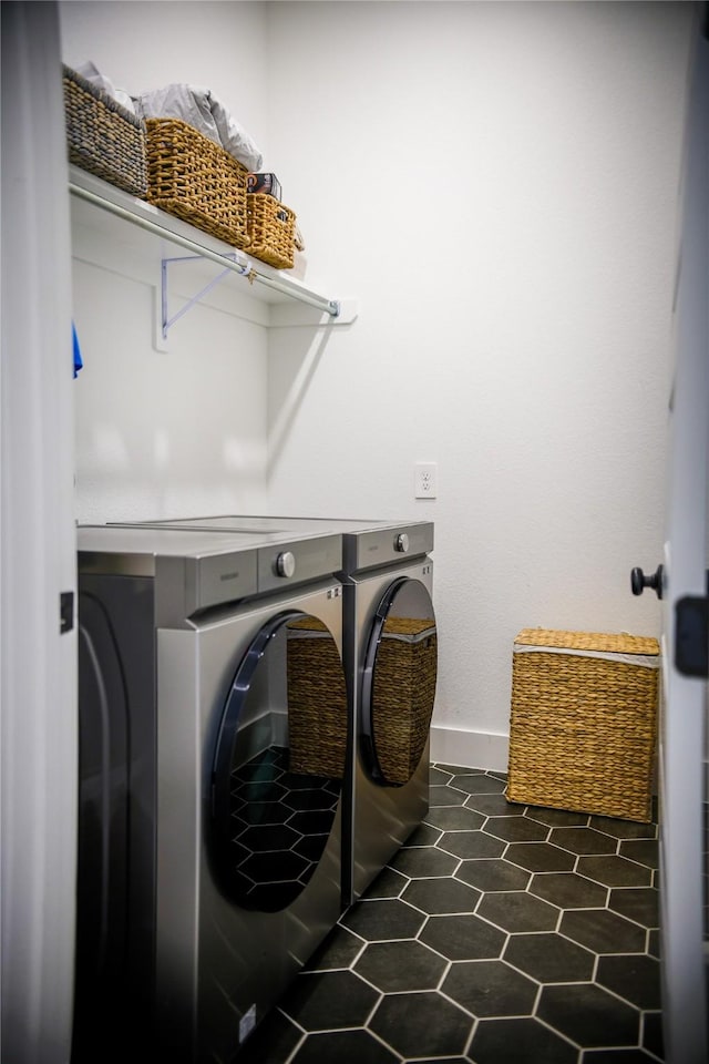 laundry room with independent washer and dryer and dark tile patterned floors