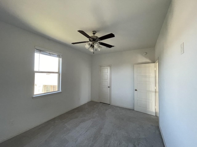 unfurnished bedroom featuring ceiling fan, light colored carpet, and a closet