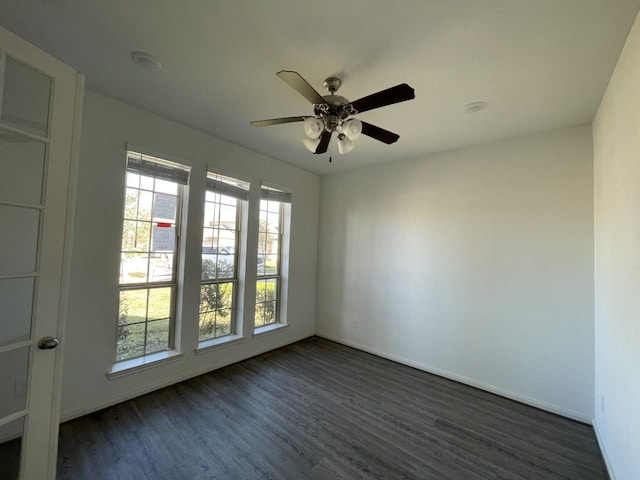 spare room with dark hardwood / wood-style flooring and ceiling fan