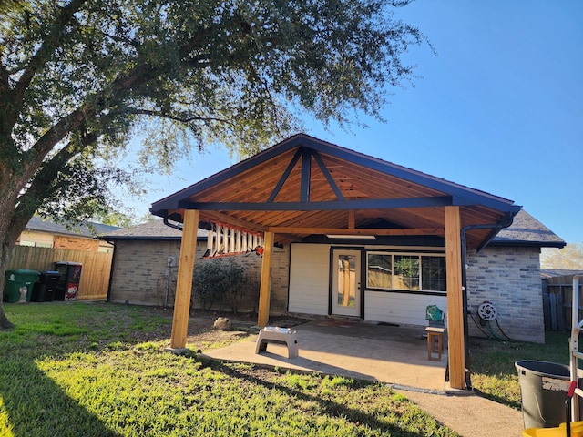 back of house with a lawn and a patio