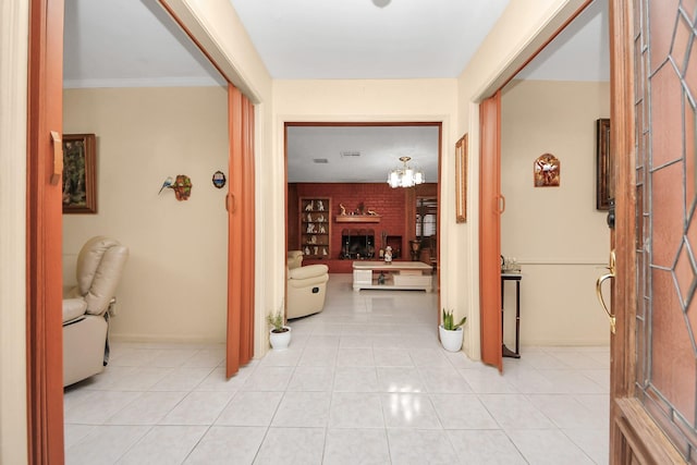 corridor with a notable chandelier, light tile patterned flooring, and ornamental molding