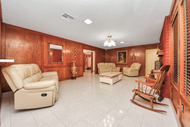 tiled living room featuring wood walls and a chandelier