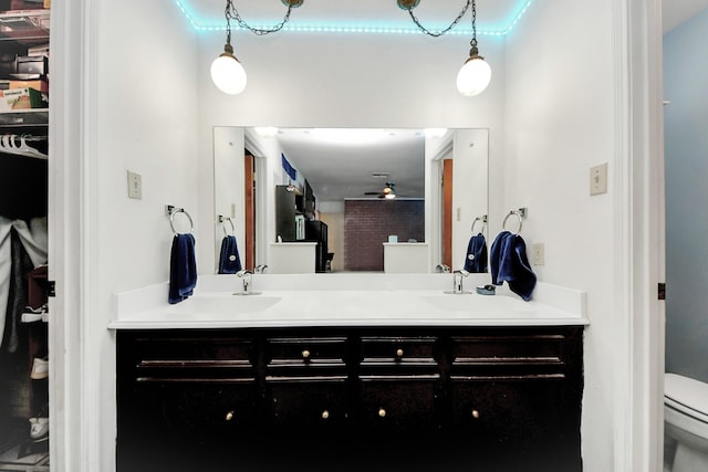 bathroom featuring ceiling fan, toilet, and vanity