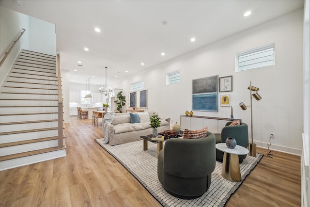 living room with light wood-type flooring and a chandelier