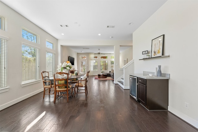 dining room with ceiling fan, dark hardwood / wood-style flooring, and beverage cooler