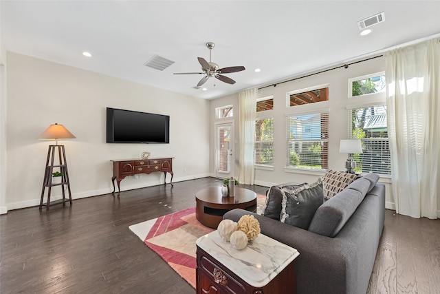 living room with ceiling fan and dark wood-type flooring