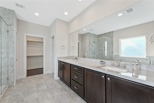 bathroom with tile patterned floors, vanity, and a shower with shower door