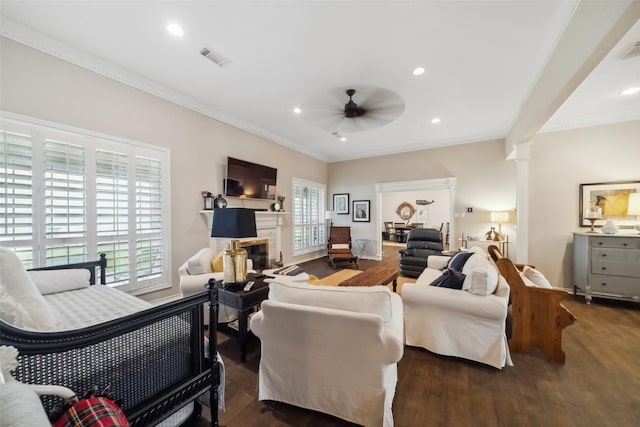 living room with ceiling fan, dark hardwood / wood-style flooring, ornamental molding, and ornate columns