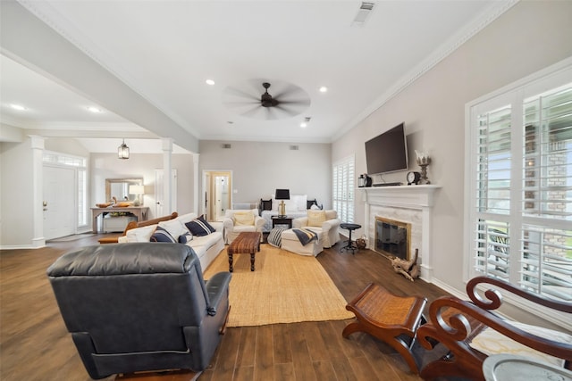 living room featuring a premium fireplace, dark hardwood / wood-style flooring, ceiling fan, and ornamental molding