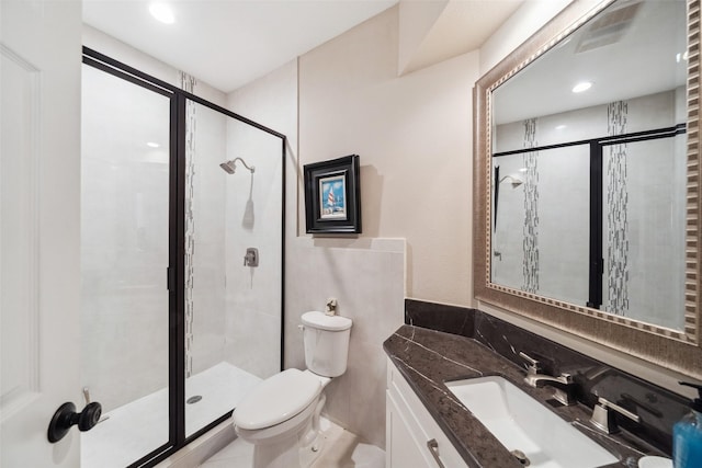 bathroom with tile patterned floors, vanity, toilet, and an enclosed shower