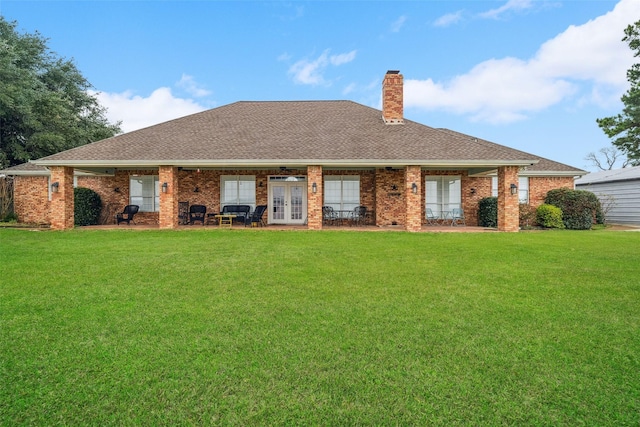 rear view of house featuring a yard and french doors