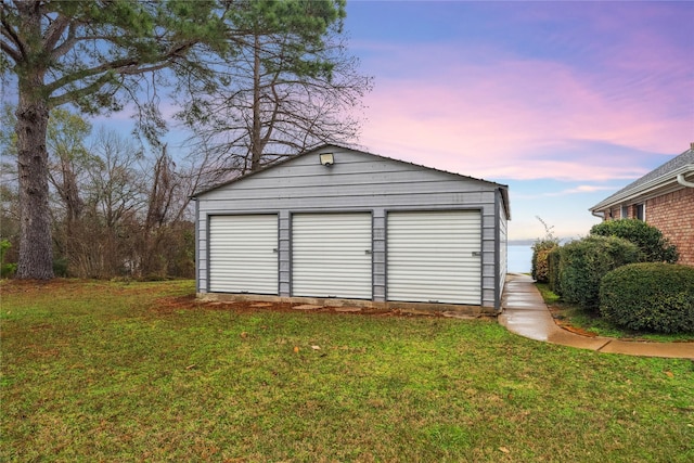 garage at dusk with a lawn