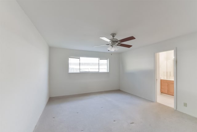 empty room with ceiling fan and light carpet