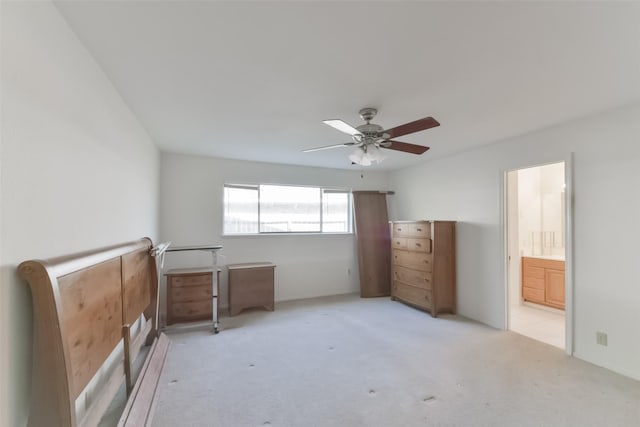 unfurnished bedroom featuring light carpet, connected bathroom, and ceiling fan