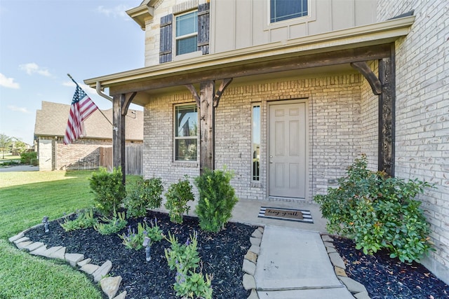 property entrance with covered porch and a yard