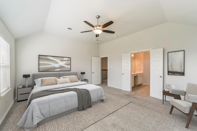 bedroom featuring ceiling fan, light carpet, connected bathroom, and vaulted ceiling