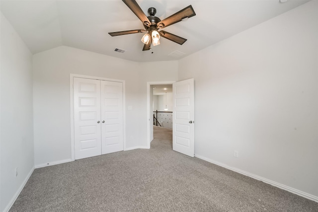 unfurnished bedroom featuring ceiling fan, a closet, carpet, and vaulted ceiling