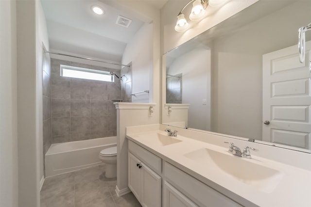 full bathroom with tile patterned floors, vanity, tiled shower / bath combo, and toilet