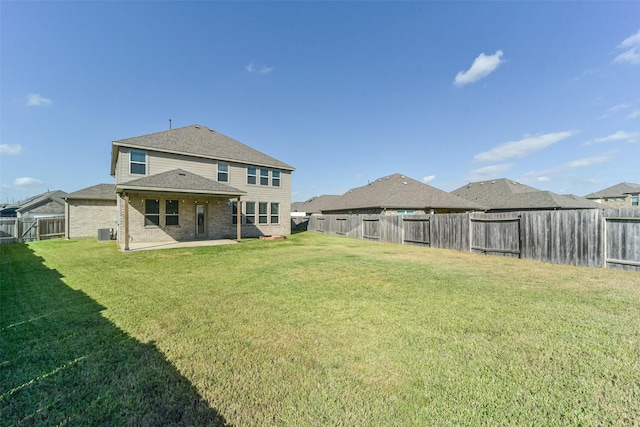 back of property with a patio area, a yard, and central AC