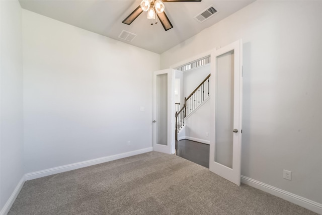 carpeted empty room featuring ceiling fan and french doors