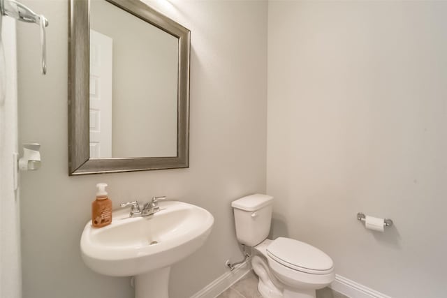 bathroom with tile patterned flooring, toilet, and sink