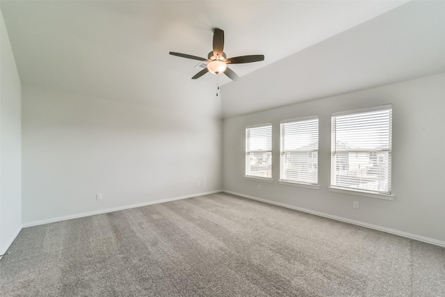 carpeted spare room featuring a wealth of natural light, ceiling fan, and lofted ceiling