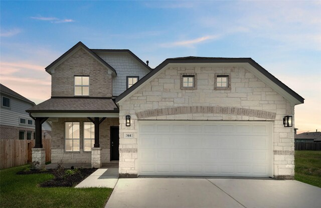 344 Spruce Oak Ln, Waller, TX 77484 - french country home featuring concrete driveway, a garage, stone siding, and roof with shingles