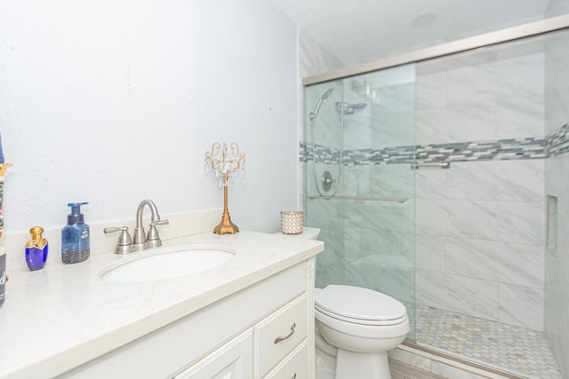 bathroom with a shower with door, vanity, and toilet