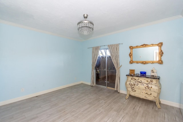 spare room featuring hardwood / wood-style flooring, an inviting chandelier, and ornamental molding