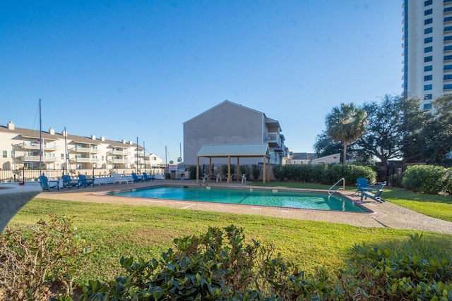 view of swimming pool with a patio area and a yard