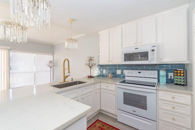 kitchen featuring a chandelier, white appliances, white cabinetry, and sink